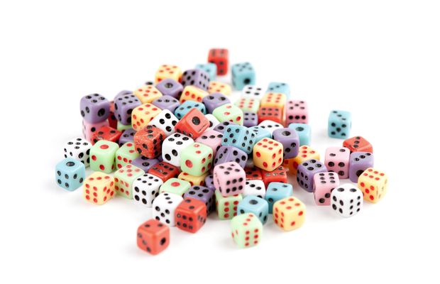 A heap of colored dice on a white table