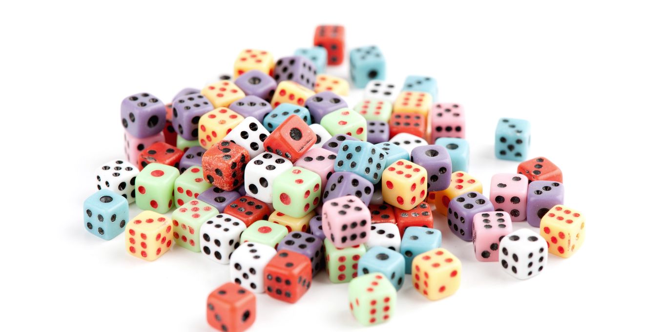 A heap of colored dice on a white table